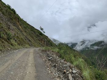 Road amidst green landscape against sky