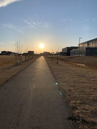 Empty road against sky during sunset