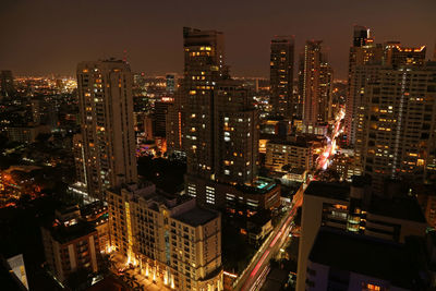 Illuminated buildings in city against sky at night