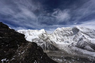 Snow covered mountains against cloudy sky