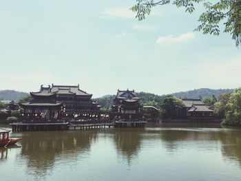 View of buildings by lake against sky