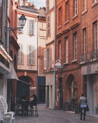 People on street amidst buildings in city