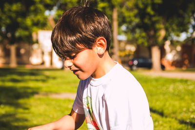 Boy standing at park during sunny day