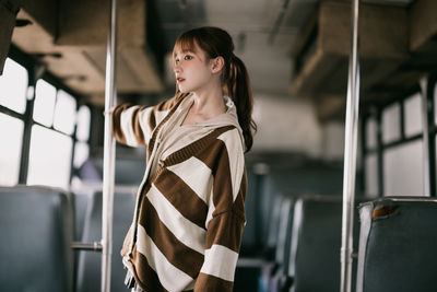 Young woman standing in train