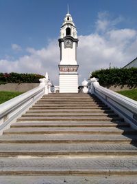 Low angle view of cross by building against sky