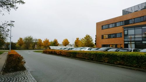 Empty road in front of buildings against clear sky