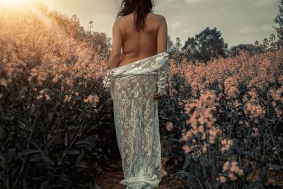 Rear view of woman standing on field