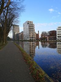 River by buildings in city against sky