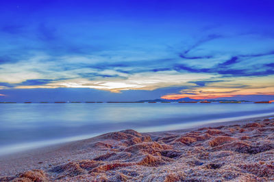 Scenic view of sea against dramatic sky during sunset