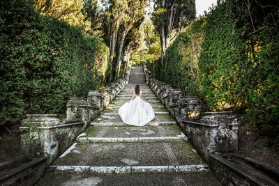 Woman walking on steps amidst trees