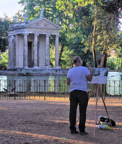 Rear view of man standing against trees