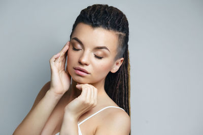 Close-up of young woman against white background