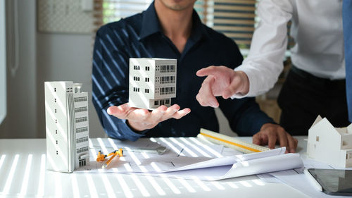 Midsection of business colleagues working on table