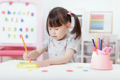 Boy drawing on book at table