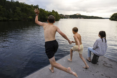 Brothers jumping into lake