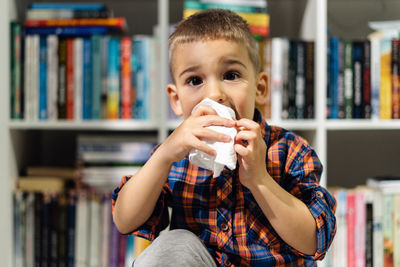 Portrait of boy drinking at home
