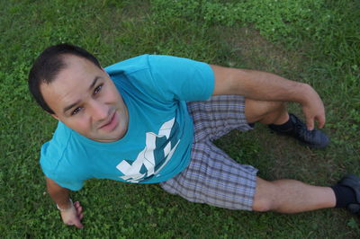 High angle portrait of man sitting on field