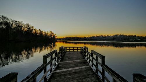 Pier on lake at sunset