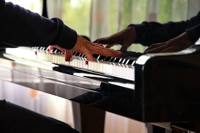 Close view of woman hand on piano keys while playing music