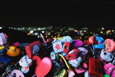 Close-up of colorful love locks in city at night
