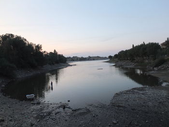 Scenic view of lake against clear sky at sunset