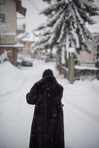 Rear view of snow covered buildings in city