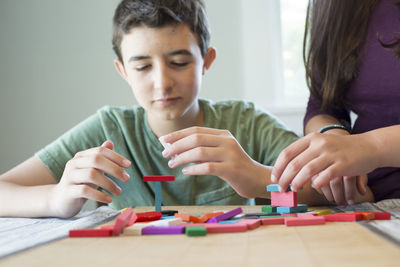 Close-up of siblings holding hands on table