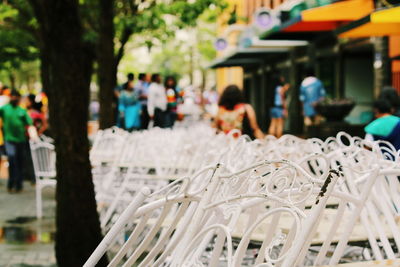 Close-up of chairs with people in background