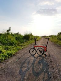 Bicycle parked on road against sky