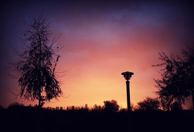 Low angle view of silhouette street light against sky at sunset