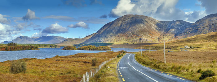 Panoramic view of road by mountains against sky