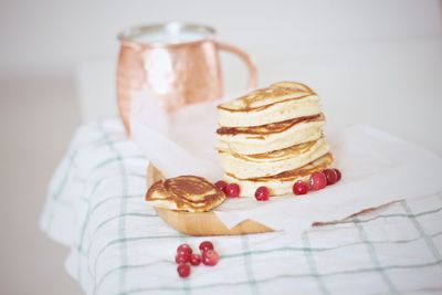 Close-up of pancakes with cherries on table