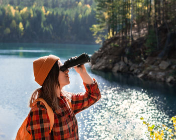 Rear view of woman photographing with camera