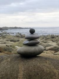 Stack of stones on beach against sky