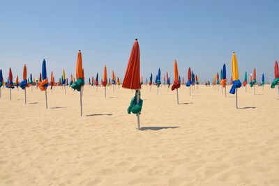 Folded beach umbrellas against clear sky