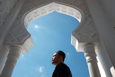 Low angle view of woman standing against sky