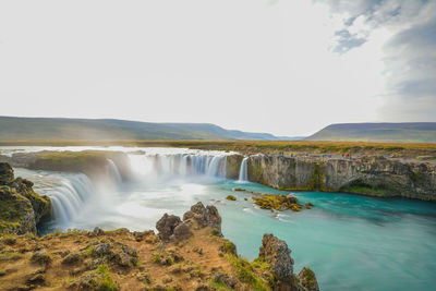 Scenic view of waterfall against sky