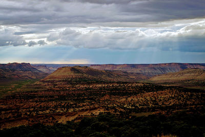 Scenic view of desert landscape against cloudy sky