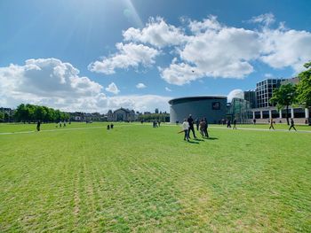 People playing on field against sky