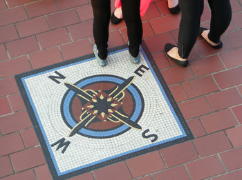 Low section of men standing on tiled floor