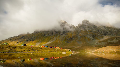 Tent on the shore of a mountain lake framed by rocky mountains. russia, arkhyz