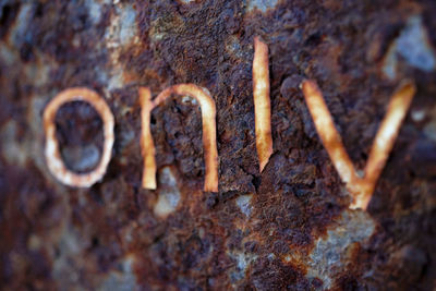 Close-up of text on rusty metal