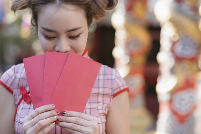 Close-up of woman holding red envelopes