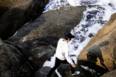 High angle view of man walking on rocks at beach