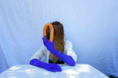 High angle view of woman sitting against blue wall