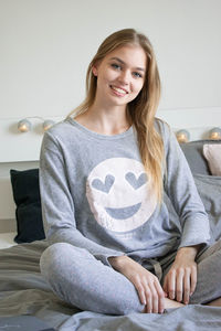 Portrait of a smiling young woman sitting at home