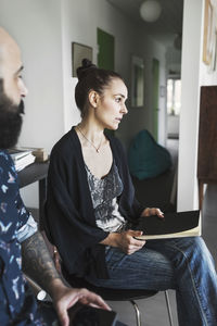 Female architect sitting with male colleague at home