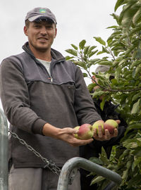 Man holding ice cream standing by plant