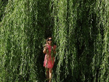 Woman standing by tree