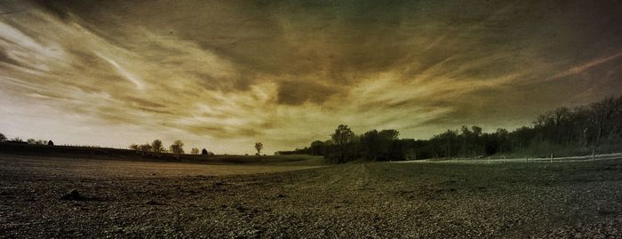 Scenic view of field against cloudy sky